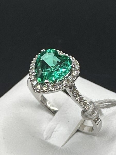 Splendido anello realizzato in oro giallo 18 carati, impreziosito da un magnifico smeraldo naturale con raffinato taglio a cuore da 1,57 carati. La pietra centrale è esaltata da una luminosa cornice di diamanti naturali che proseguono armoniosamente lungo il gambo, regalando brillantezza da ogni angolazione.
L’anello pesa 3,09 grammi ed è impreziosito da diamanti naturali per un totale di 0,38 carati, di colore G, selezionati per la loro luminosità e qualità.
Un gioiello elegante e senza tempo, perfetto per celebrare un’occasione speciale o come preziosa dichiarazione d’amore. La combinazione tra il verde intenso dello smeraldo e lo scintillio dei diamanti rende questo anello un capolavoro di raffinatezza e stile.
